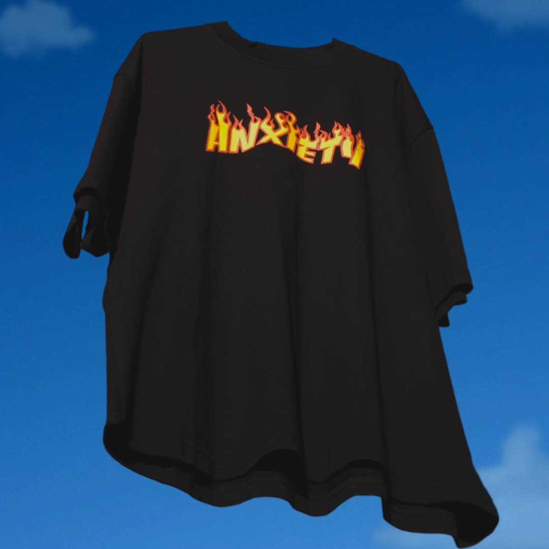 Black t-shirt with 'ANXIETY' in flames on a blue sky background