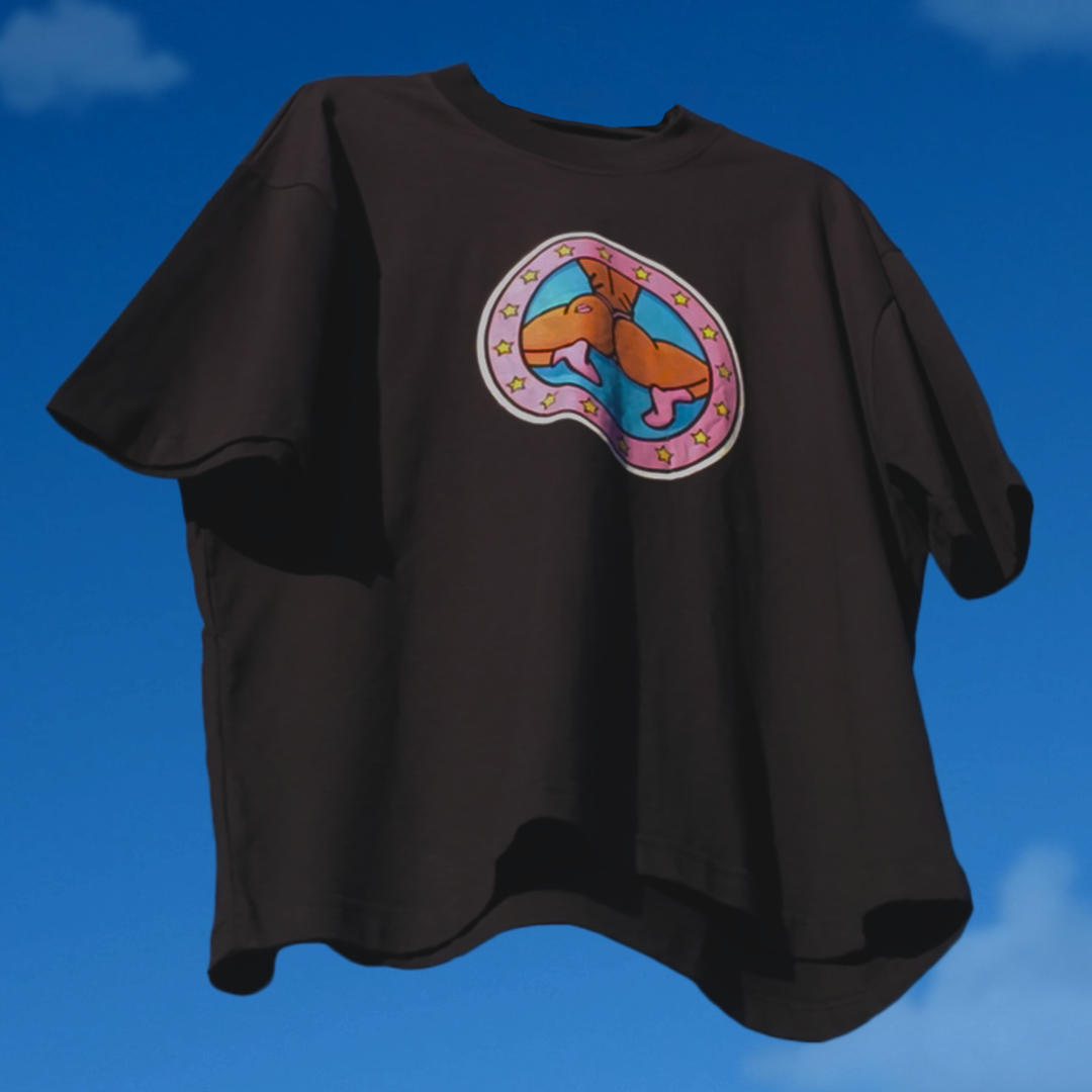 Black t-shirt with colorful graphic design on a blue sky background